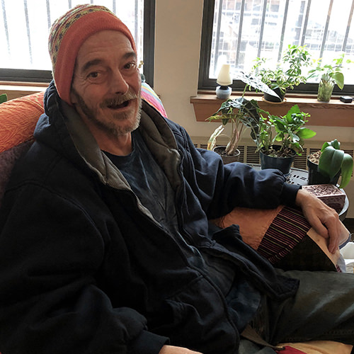 Tim, a Plymouth resident, in his home with recliner and plants